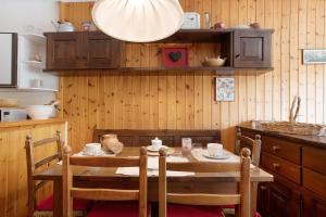 a kitchen with a wooden table with chairs and a dining room at Appartamenti Larice Pila in Pila