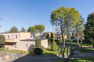 a view of a building with trees and bushes at La Pelusa Peschiera in Peschiera del Garda