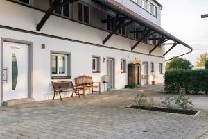 a white building with a table and chairs on a patio at Pension Zum Talhof in Reichenau