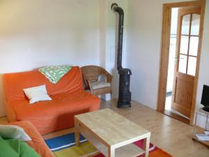 a living room with an orange couch and a wood stove at Alte Wassermühle in Salem