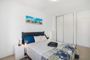 a bedroom with a bed and a white wall at El Pisito de Momo in Candelaria +13 photos