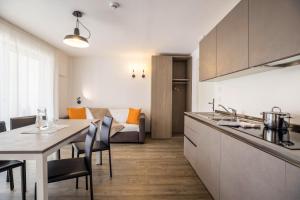 a kitchen and living room with a table and chairs at Apartment Treï Residence Bun Ste in San Vigilio Di Marebbe