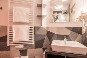 a bathroom with a sink and a mirror and towels at Apartment Treï Residence Bun Ste in San Vigilio Di Marebbe +22 photos