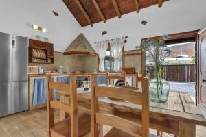 a kitchen with a wooden table and wooden chairs at La Casilleta in Betancuría