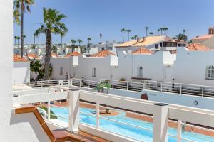 a view of the pool from the balcony of a resort at La Casita Encantada in Corralejo