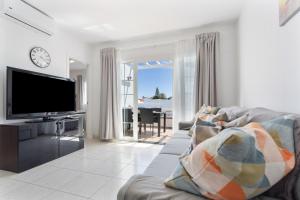 a living room with a couch and a flat screen tv at La Casita Encantada in Corralejo