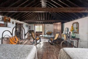 a bedroom with two beds and chairs in a room at La Tunera in La Cisnera