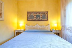 a bedroom with a white bed with two night stands at Casa Marina a 150mt dalla pelosa in Stintino