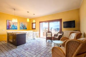 a living room with yellow walls and a tv at Casa Marina a 150mt dalla pelosa in Stintino