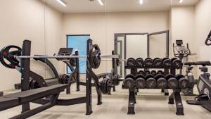 a gym with lots of equipment in a room at Apartament Diuna z dostępem do basenu, siłowni, hali sportowej, sauny in Gąski