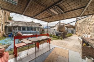 a patio with a table and a bench under a roof at Amontes Rural in Nestar