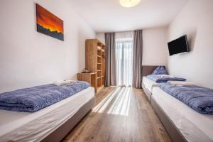 a room with two beds and a television at Ferienwohnung Sonneck in Natz-Schabs