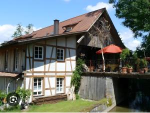 a house with a bridge next to a river at Alte Wassermühle in Salem
