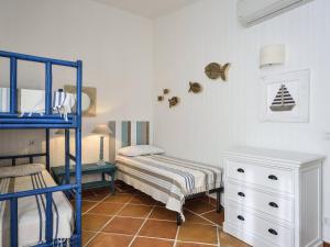 a bedroom with two beds and a bunk bed at Li Conchi 44 in Castiadas