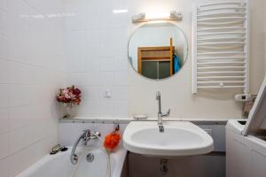 a bathroom with a sink and a mirror and a tub at Les arolles in Valloire