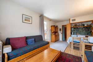 a living room with a couch and a table at Les arolles in Valloire +16 photos