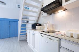 a kitchen with white cabinets and a staircase at Appartement Guillaume vue mer in Trégunc +22 photos
