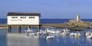 a group of boats in the water near a building at Appartement Guillaume vue mer in Trégunc