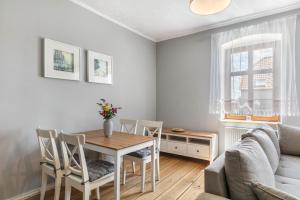 a living room with a table and chairs and a couch at Ferienwohnung mit großem Garten in Lindow