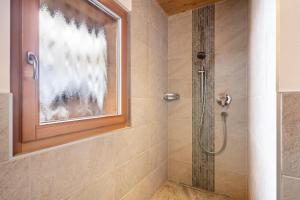 a shower with a glass door in a bathroom at Seppnerhof Ferienwohnung Enzian in Moso