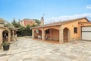 a house with a patio and a garage at Casa Raymond con piscina in Maçanet de la Selva
