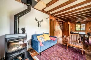 a living room with a blue couch and a wood stove at Chalet Chez Juju in Abondance