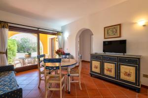 a living room with a table and a tv at Trilocale Fiordaliso in Stintino