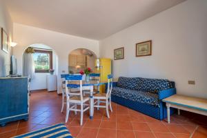 a living room with a couch and a table at Trilocale Fiordaliso in Stintino