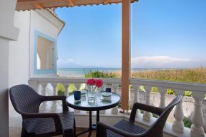 a table and chairs on a balcony with a view of the ocean at Apartment Vorrisi in Alykes