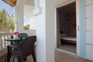 a balcony with a table and chairs and a bedroom at Apartment Vorrisi in Alykes +18 photos