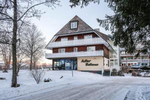 a building with a gambrel roof in the snow at Ferienhaus Adler Bellevue in Hinterzarten