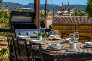 a table with wine glasses and a grill on a patio at Casa Martin in Calvià