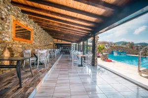 an outdoor patio with tables and chairs and a pool at Mirage Arillas Studio Type C19 in Arillas +14 photos