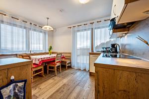 a kitchen with a table and a dining room at Maurerhof Abendrot in Maranza +10 photos