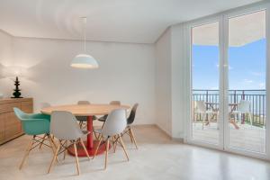 a dining room with a table and chairs and a balcony at Javea Brisas Del Mar Cofisa in Jávea