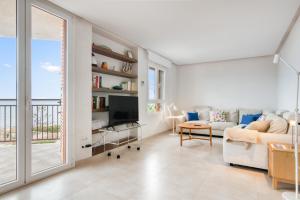 a living room with a couch and a tv at Javea Brisas Del Mar Cofisa in Jávea