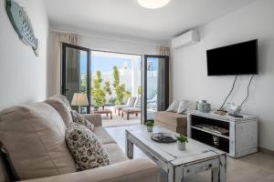 a living room with a couch and a tv at Alegria in Puerto del Carmen