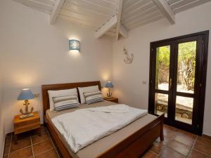 a bedroom with a bed with two lamps and a window at Villa Luna Rossa con piscina in San Teodoro