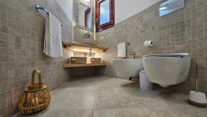 a bathroom with a sink and a toilet and a mirror at Villa Luna Rossa con piscina in San Teodoro +35 photos