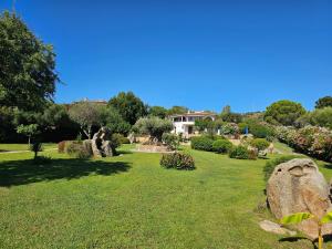 a garden with a house in the background at Villa Luna Rossa con piscina in San Teodoro
