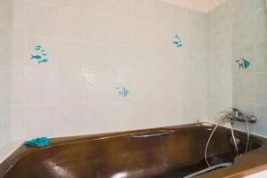 a bath tub in a bathroom with blue fish on the wall at Gîte Ty Coz in Lanvellec +18 photos