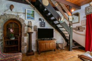 a living room with a staircase with a tv in a room at Gîte Ty Coz in Lanvellec
