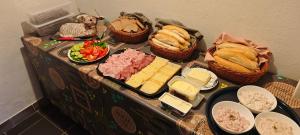 a table with cheese and meats and baskets of food at Penzion Bobas in Jindřichŭv Hradec