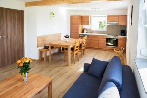 a living room with a blue couch and a table at Bauernhof Mayer in Owingen
