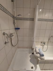 a bathroom with a tub and a shower with towels at Ferienwohnung-Pension Osterwiese in Weilburg