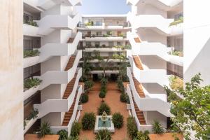 an apartment building with white balconies and plants at Guadalmina Alta in Marbella