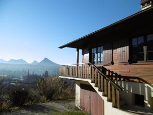 a house with a balcony with a view of the mountains at L'Arête de Chalamon in Menthon-Saint-Bernard