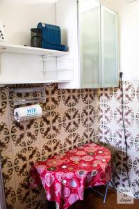 a kitchen with a table with a red table cloth at Encanto da Praia in Santo André +29 photos