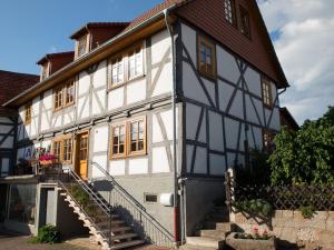 an old white and black building with a staircase at Fachwerktraum im Hof in Alheim