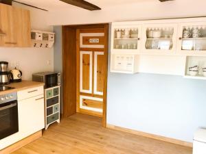 a kitchen with white cabinets and a stove top oven at Fachwerktraum im Hof in Alheim +8 photos